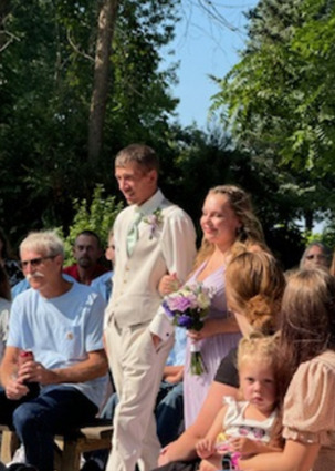 Caitlin walking down aisle with groomsman